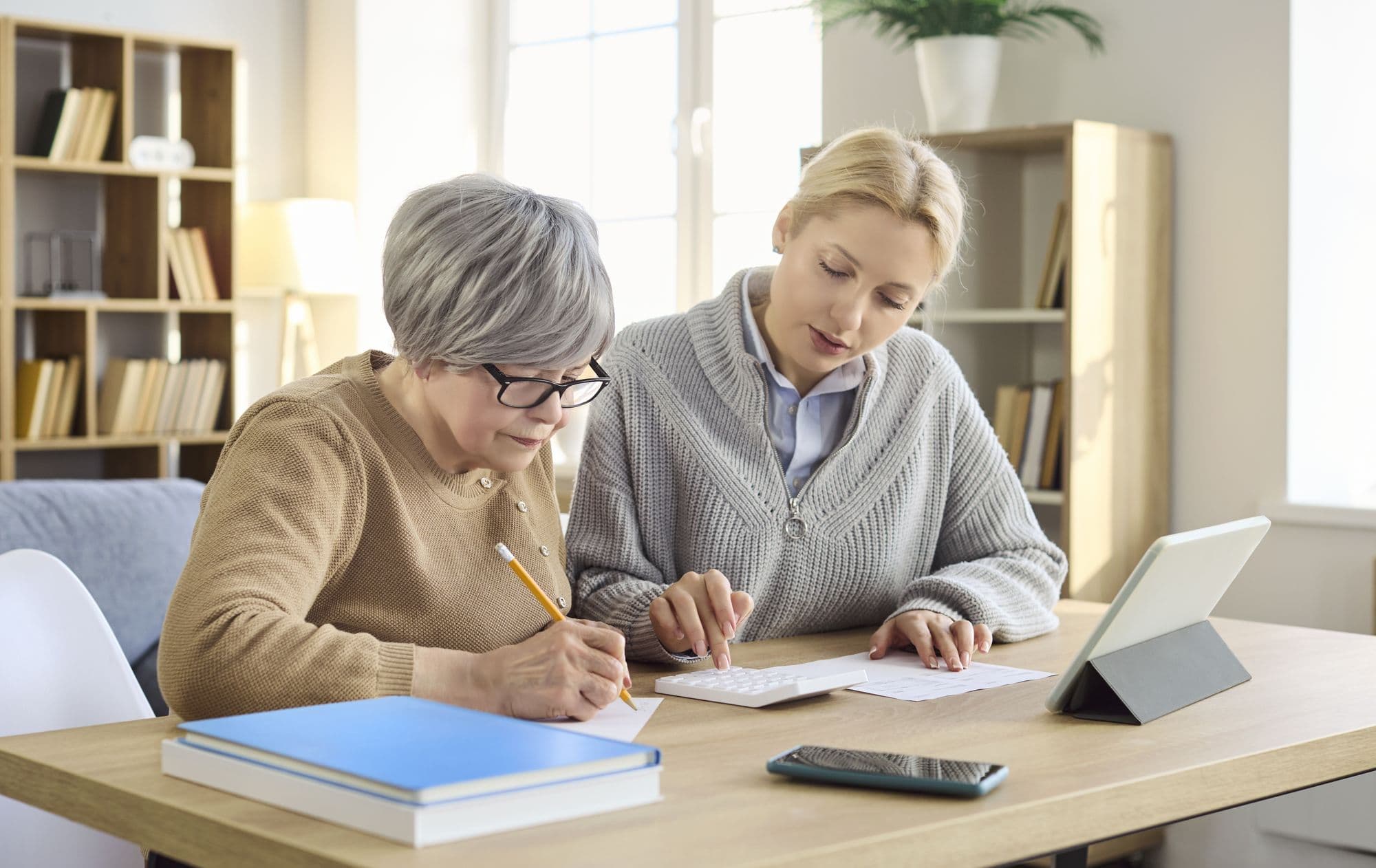 An older adult and a family member review paperwork together at home.
